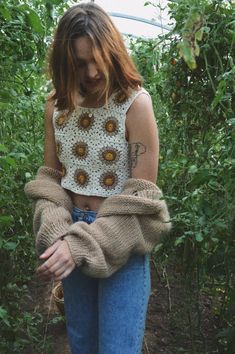 a woman standing in the middle of some plants