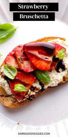 strawberry bruschetta on a white plate with basil leaves