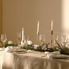 the table is set with wine glasses and candles