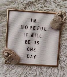 a sign that says i'm hopeful it will be us one day with two baby shoes