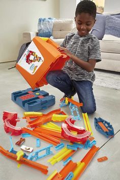 a young boy playing with toys on the floor