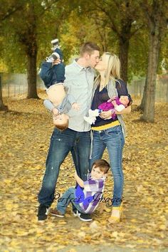 a family posing for a photo in the leaves