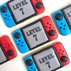 four cookies decorated like video game controllers with the words level 7 and 7 on them