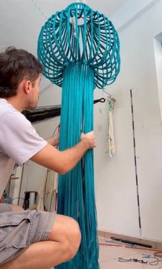 a man is working on something that looks like a wind chime in the air