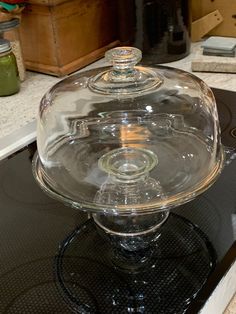 a glass cake dish sitting on top of a stove