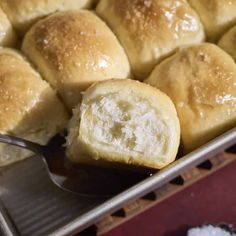 a pan full of rolls with butter on top