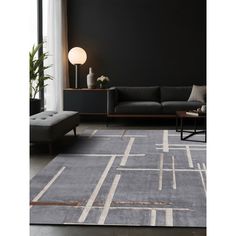 a living room with a couch, chair and rug in grey tones on the floor