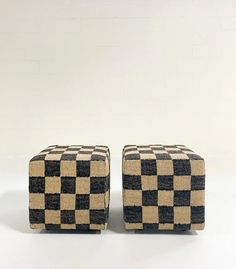 two black and white checkered ottomans sitting next to each other on a white surface