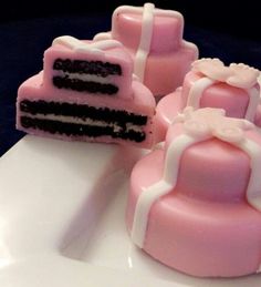 three pink and white cakes sitting on top of a plate