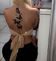 the back of a woman's body with butterflies on her upper and lower back