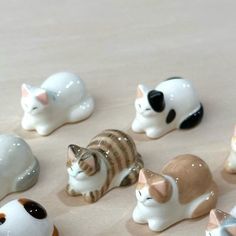 a group of small ceramic cats sitting on top of a table