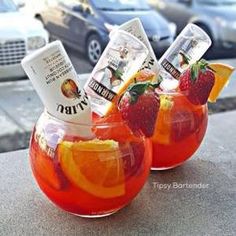 two glasses filled with fruit punch sitting next to each other on top of a table