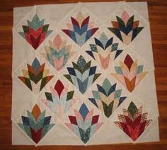 a quilted table topper with many different designs on it's sides, including flowers and leaves