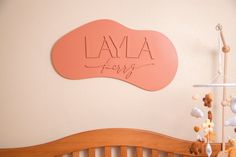 a baby crib with a pink sign that says lamaa merry on it's wall