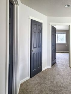 an empty room with two black doors and carpet