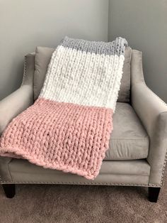 a gray chair with a pink and white blanket on it