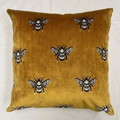 a yellow pillow with black bees on it