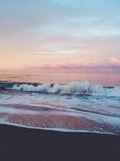 an image of the ocean at sunset with waves coming in to shore and pink sky