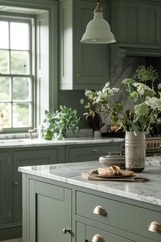 a vase filled with flowers sitting on top of a kitchen counter