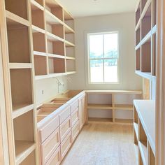 an empty room with lots of shelves and cupboards in the corner, along with a window