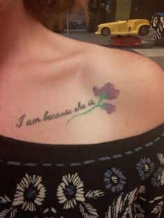 a woman with a tattoo on her shoulder that says, i am because she is