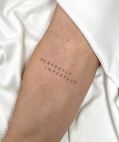 a person with a tattoo on their arm that reads perfectly imperfect