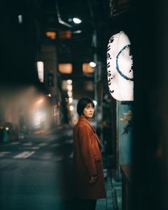 a woman standing in an alley at night