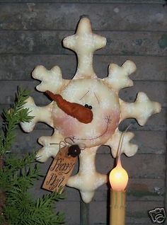 a snowflake ornament with a candle in front of it