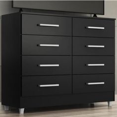 a black dresser with drawers and a flat screen tv mounted on it's side