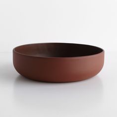 a brown bowl sitting on top of a white table