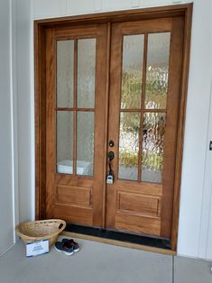 a pair of shoes sitting on the ground in front of a wooden door with glass panels