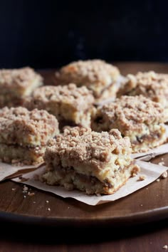 several pieces of dessert sitting on top of a wooden cutting board