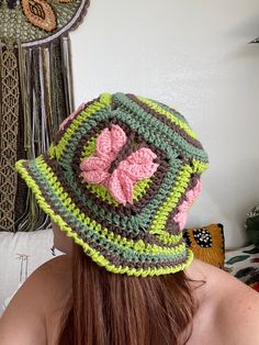 a woman wearing a crocheted hat with flowers on it