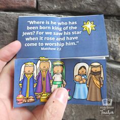 a hand holding up a card with an image of the three wise men and mary