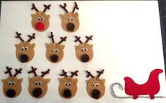 a group of reindeers made out of paper on a white board with a red nose