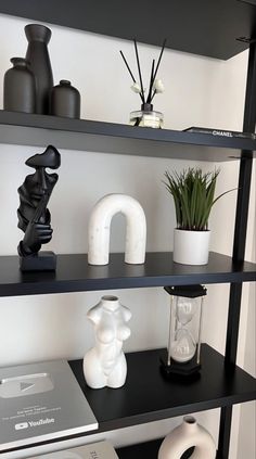 shelves with vases, books and other items on top of them in a room