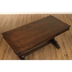 a wooden coffee table with drawers on the bottom and one drawer at the top, sitting on a hard wood floor