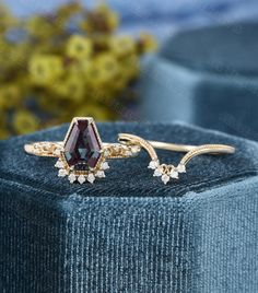 an image of two rings on top of a velvet box with flowers in the background