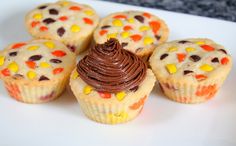 some cupcakes with chocolate frosting and candy corn on top are sitting on a white plate