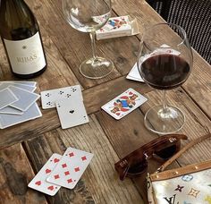 wine, playing cards and sunglasses on a wooden table