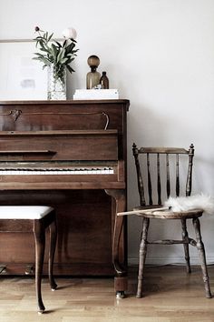 an old piano and chair in a room