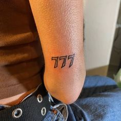 a person with a small tattoo on their left arm and the word pi in cursive writing