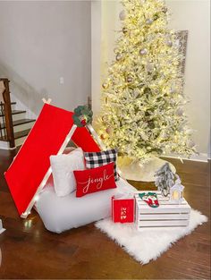 a white christmas tree in the corner of a room with red and white pillows on it