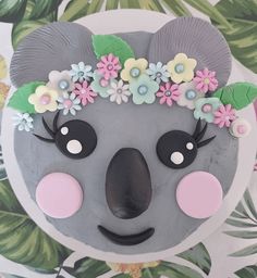 a cake decorated to look like a koala bear with flowers on it's head