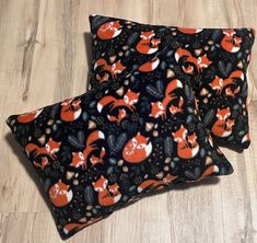 two black and orange pillows with foxes on them