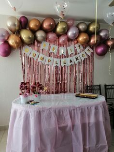 a table topped with pink and gold balloons