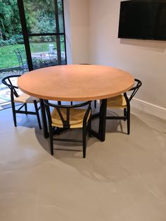 a table with four chairs and a television mounted to the wall in front of it