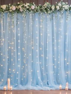 the backdrop is decorated with white flowers and lit candles for an elegant wedding or special event