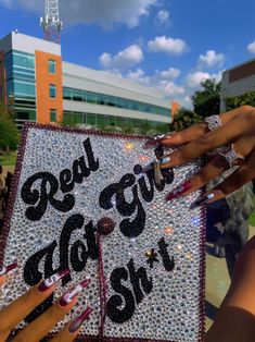 two hands holding up a graduation cap that says real girls do it