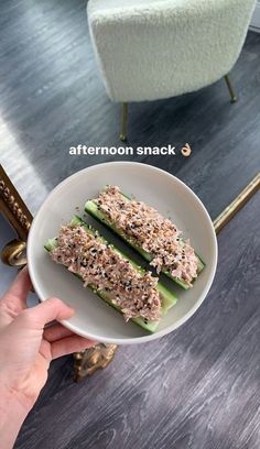 someone is holding a plate with some food on it and there are other things in the bowl